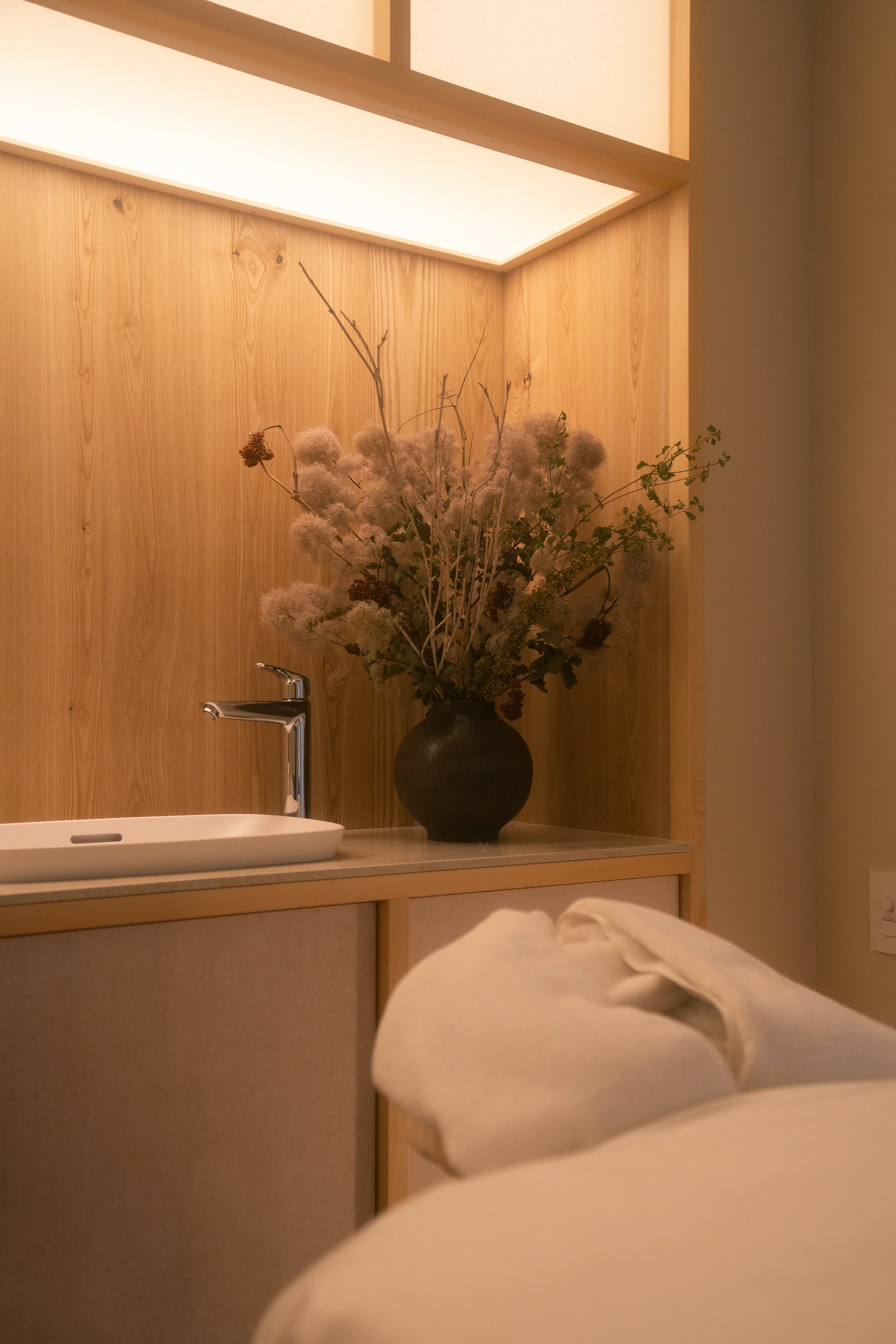 Warmly lit spa treatment room with a floral arrangement at Raiden Resort